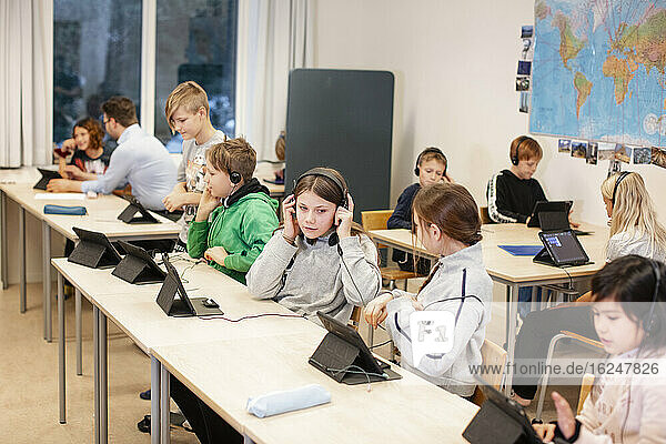 Children in classroom using digital tablet