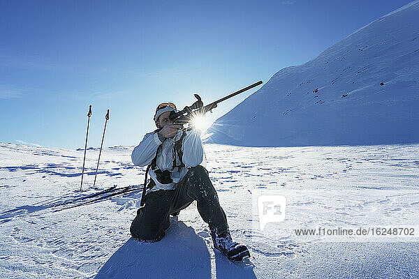 Cross country skier aiming rifle
