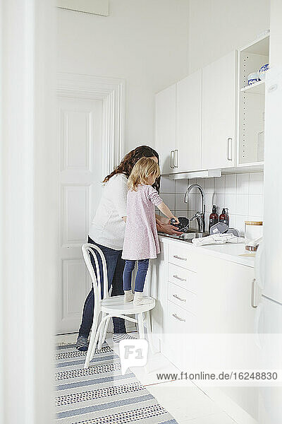 Mutter und Tochter beim Geschirrspülen