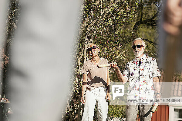 Senior couple in garden playing kubb