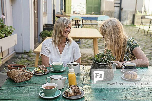 Weibliche Freunde trinken Kaffee in einem Straßencafé