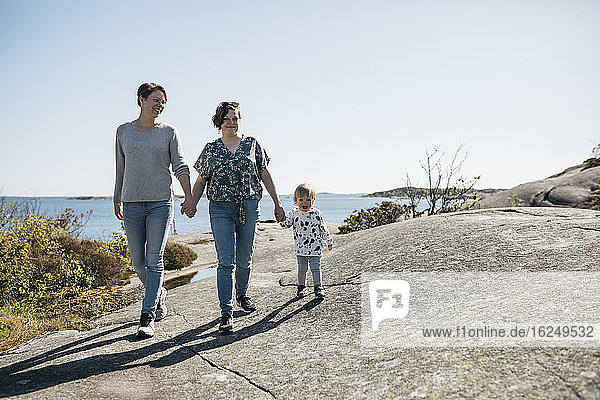 Mothers walking with daughters on coast