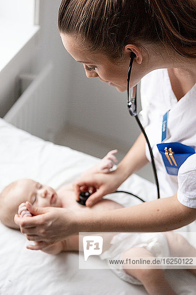 Female doctor examining baby