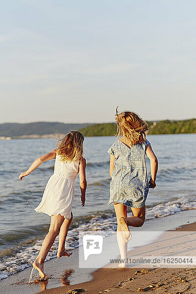 Mädchen laufen am Strand