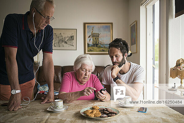 Mann zeigt älterer Frau Mobiltelefon