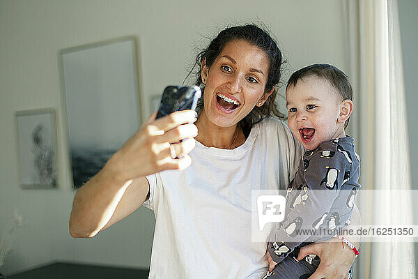 Mother taking selfie with toddler son