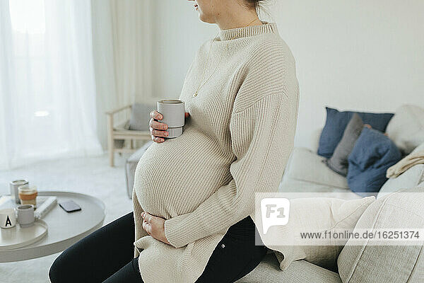 Schwangere Frau entspannt sich im Wohnzimmer