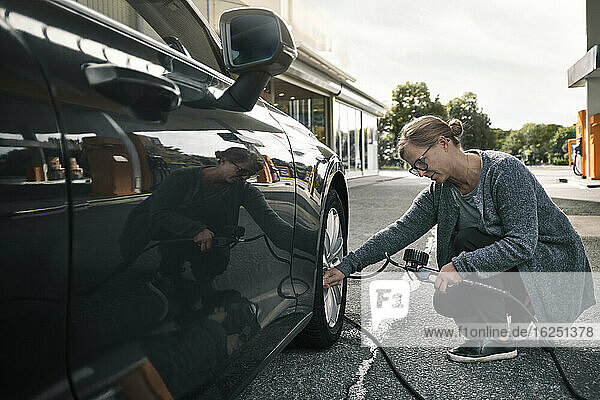 Woman filing air in car tire