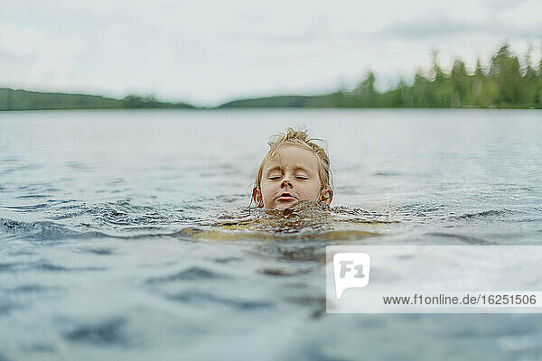 Mädchen schwimmt im See