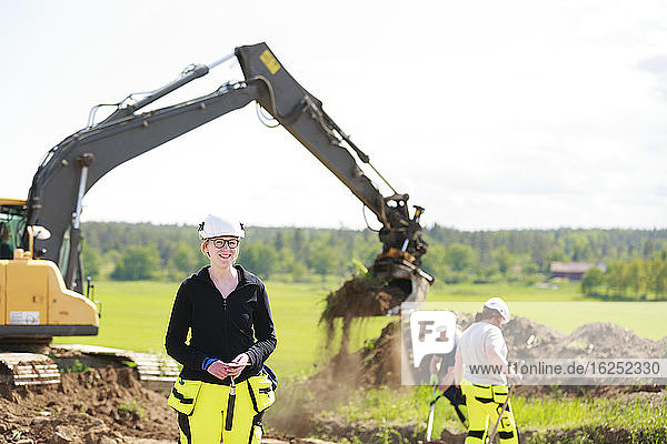 Female worker with digger on background
