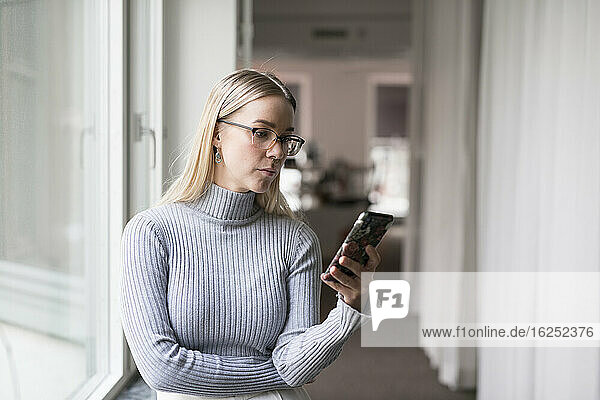 Junge Frau mit Smartphone im Büro