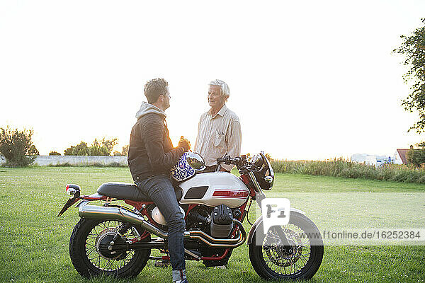 Vater mit erwachsenem Sohn in der Nähe des Motorrads