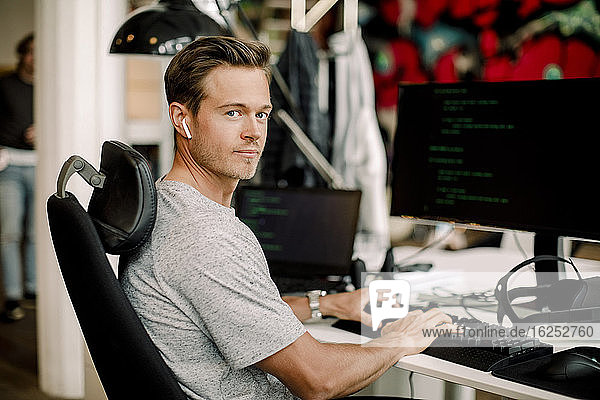 Porträt eines männlichen Computerprogrammierers  der im Büro arbeitet