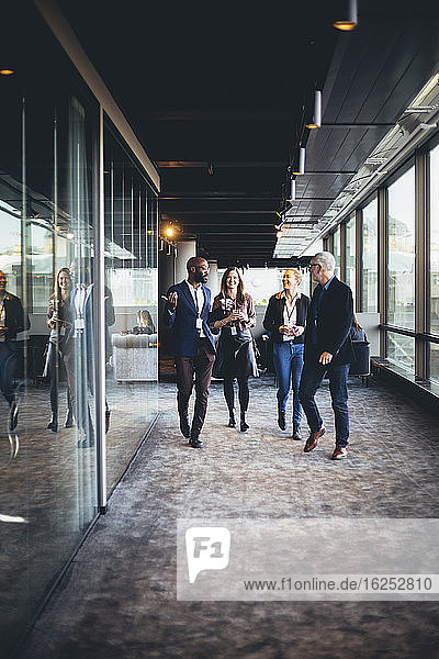Male and female entrepreneurs walking in office corridor