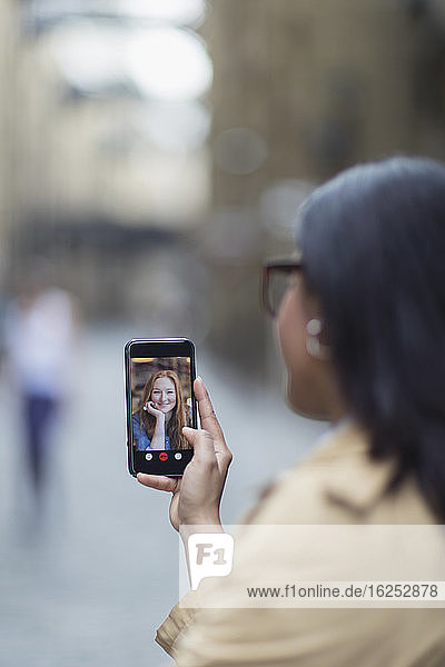 Women video chatting on smart phone screen