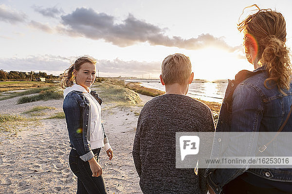 Porträt eines Teenagers mit Familie am Strand