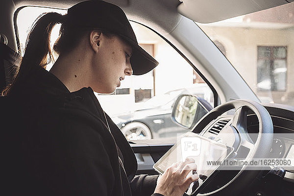 Seitenansicht des Fahrers mit digitalem Tablett im Lkw