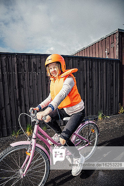 Lächelndes Mädchen fährt Fahrrad auf der Straße