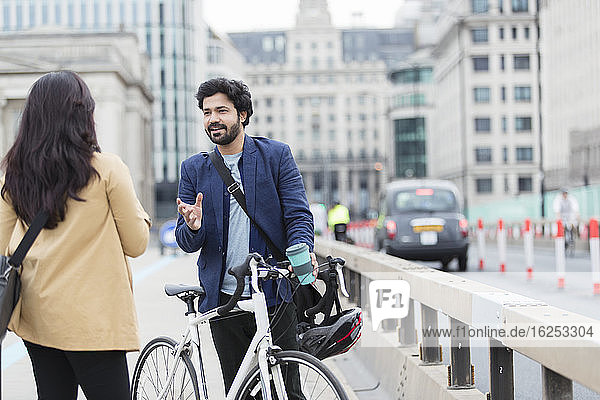 Geschäftsleute mit Fahrrad sprechen auf Stadtbrücke
