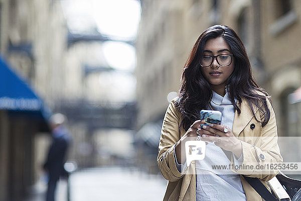 Frau benutzt Smartphone auf der Straße in der Stadt