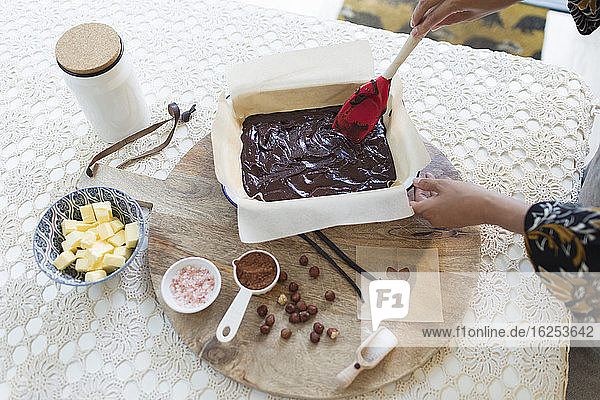 Frau backt Schokoladenkuchen am Esstisch
