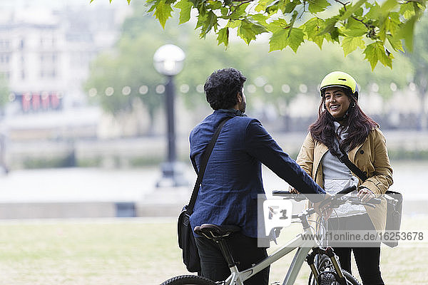 Business people with bicycles talking in city park
