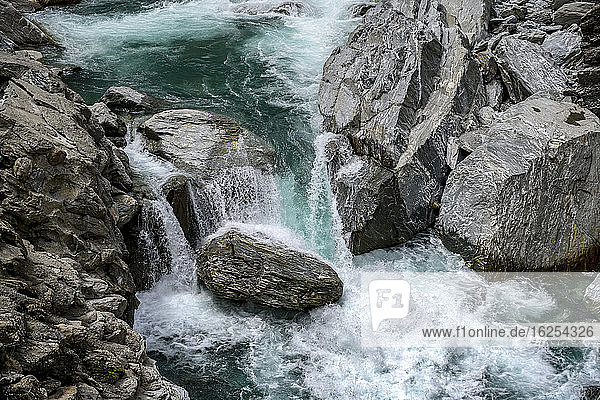 Blaue Wasserkaskaden über Felsen in einem rauschenden Fluss  Haast Pass  Mount Aspiring National Park  Südinsel; Westküstenregion  Neuseeland