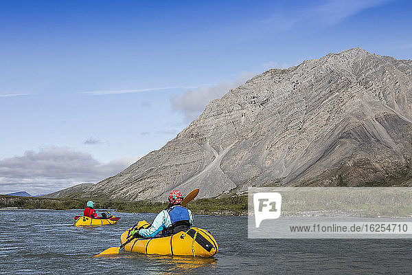 Two women paddle down the Canning River on a sunny late summer day through the Brooks Range  Arctic National Wildlife Refuge; Alaska  United States of America