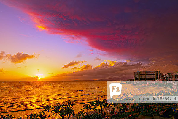Waikiki Beach in lebhaften Farben bei Sonnenuntergang mit einer dramatischen glühenden Wolkenformation über dem Strand; Honolulu  Oahu  Hawaii  Vereinigte Staaten von Amerika