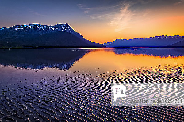 Sonnenuntergang am Turnagain Arm des Cook Inlet. Während der Ebbe wird ein welliges Wattenmeer sichtbar  im Hintergrund die Chugach-Berge. Süd-Zentral-Alaska im Sommer; Portage  Alaska  Vereinigte Staaten von Amerika