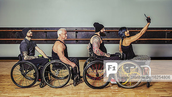 Eine Gruppe querschnittsgelähmter Freunde  die nach einem Training in einer Fitnesseinrichtung herumalbern und ein Selbstporträt ihres Rollstuhlzuges anfertigen: Sherwood Park  Alberta  Kanada