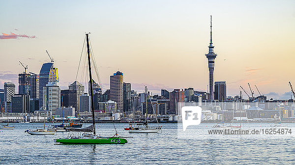 Boote im Hafen entlang der Küste von Auckland,  bei Sonnenuntergang vom Sulphur Beach Reserve aus gesehen; Auckland,  Nordinsel,  Neuseeland