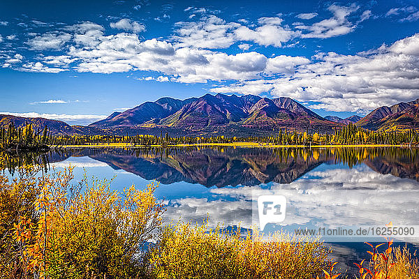 Gebirgskette spiegelt sich am Mentasta-See mit herbstlich gefärbtem Laub unter blauem Himmel  Tok vom Glenn Highway abgeschnitten  Süd-Zentral-Alaska im Herbst; Alaska  Vereinigte Staaten von Amerika