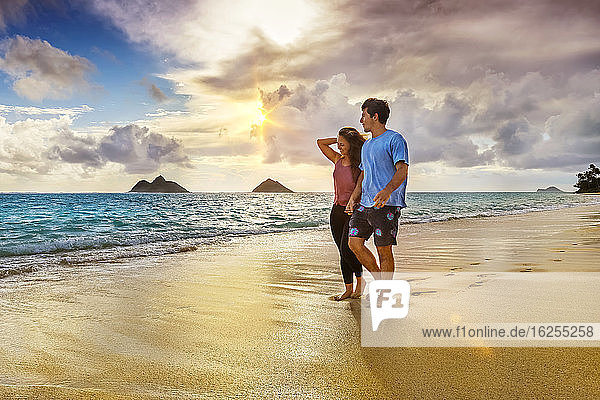 Ein Paar spaziert bei Sonnenuntergang am Strand von Lanakai auf der hawaiianischen Insel Oahu; Lanakai  Oahu  Hawaii  Vereinigte Staaten von Amerika