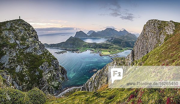 Tiny person stands at the summit and looks out over the wide sea  at the back Lofoten mountains  Offersoykammen  Leknes  Lofoten  Nordland  Norway  Europe