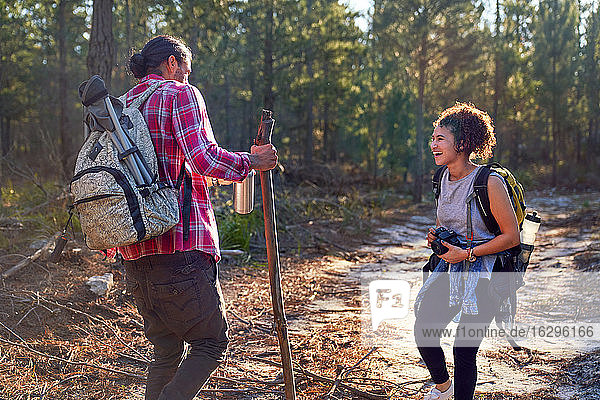Happy young couple hiking in sunny woods