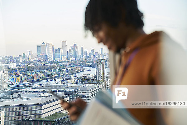 Geschäftsmann mit Smartphone am Hochhausfenster  London  UK