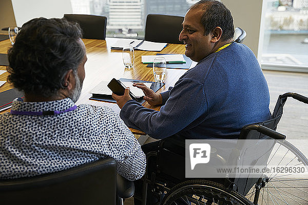 Geschäftsmann im Rollstuhl im Gespräch mit Sitzungskollege