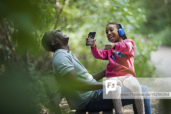 Glücklicher Vater und Tochter lachen auf der Parkbank