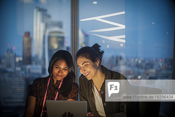 Geschäftsfrauen mit digitalem Tablet arbeiten spät im Büro London UK