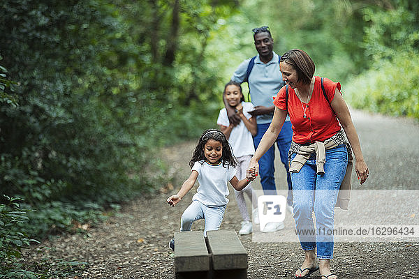 Happy family walking on trail in woods