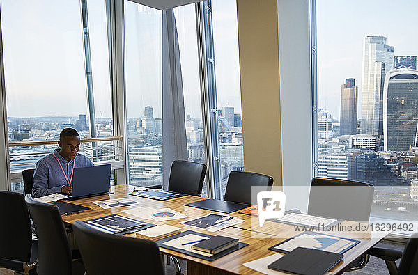 Geschäftsmann arbeitet am Laptop im Hochhaus-Konferenzraum London UK