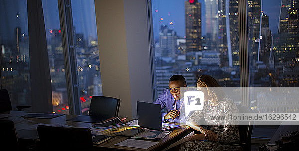 Geschäftsleute  die spät am Laptop im Hochhausbüro arbeiten  London  UK