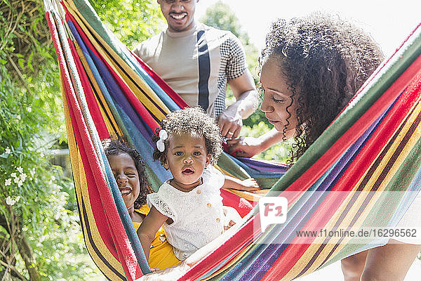 Porträt eines süßen Kleinkindes in sonniger Sommerhängematte mit Familie