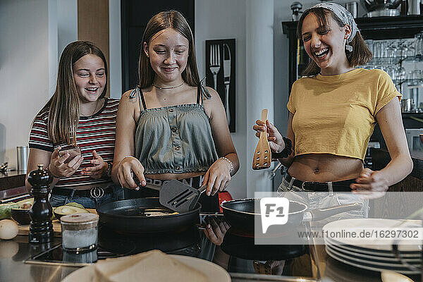 Freundinnen bereiten gemeinsam ein gesundes Mittagessen zu  braten Eier in der Küche