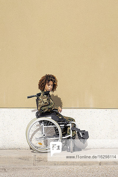 Weiblicher Offizier im Rollstuhl sitzend an der Wand