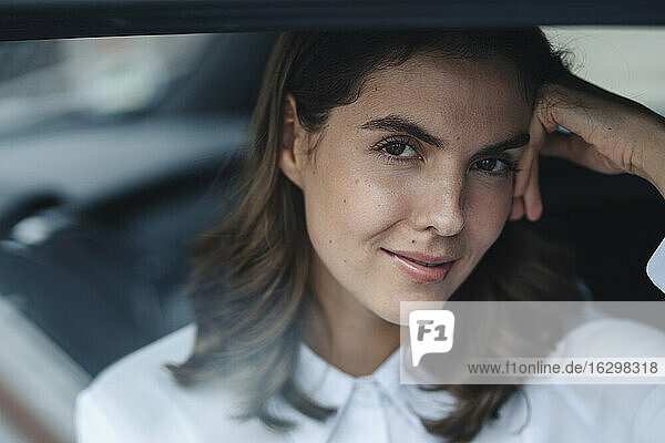 Junge Frau mit Kopf in den Händen im Auto sitzend