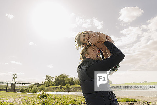 Vater spielt mit seiner Tochter  während er sie an einem sonnigen Tag abholt