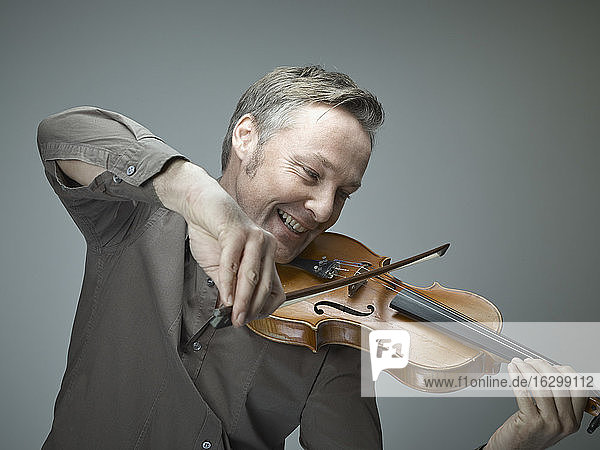 Porträt eines lächelnden Mannes  der Geige spielt