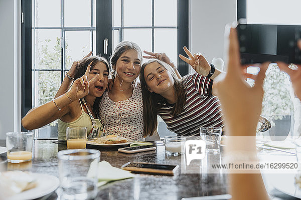 Gruppe von Teenagermädchen trifft sich zum Brunch und macht Smartphone-Fotos